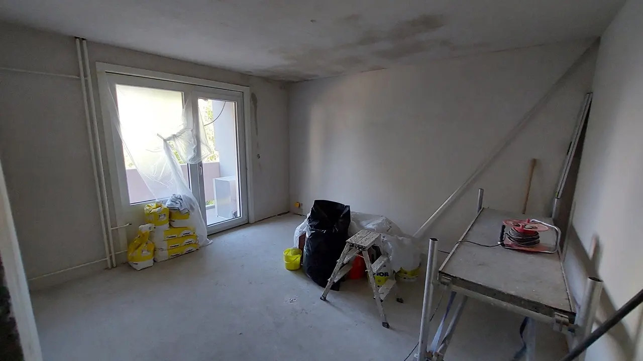 Travaux de plâtrerie et préparation des surfaces dans le séjour à Fribourg.