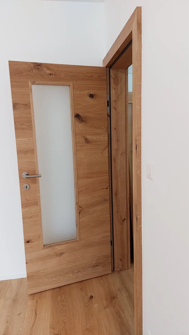 Gros plan sur les finitions de menuiserie et les poignées de porte à Fribourg.