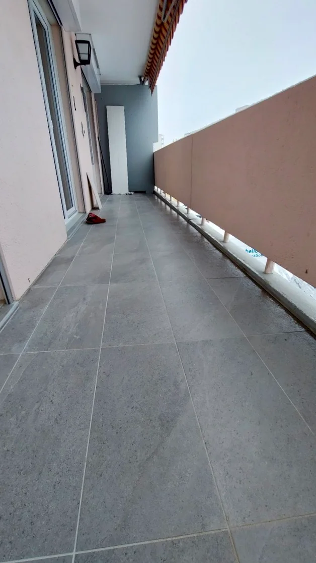 Nouveau carrelage de balcon gris grand format posé à Fribourg.